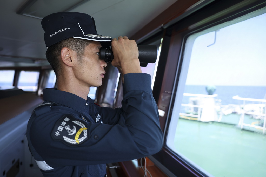 5月5日，海警川山舰执法员廖静龙在巡航警戒演练中瞭望海面情况。新华社记者 陈斌 摄