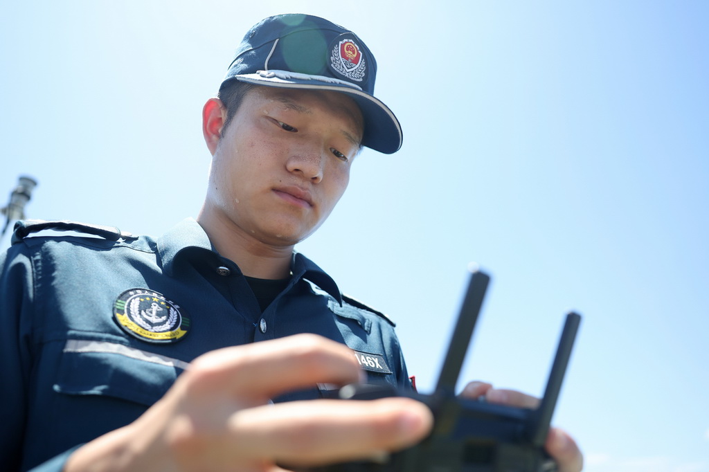 5月5日，海警川山舰执法员桂子杰在甲板上操控无人机进行执法取证演练。新华社记者 陈斌 摄