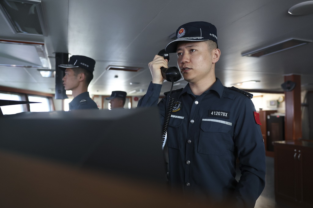 5月5日，海警川山舰执法员陈浩（右一）进行喊话警告演练。新华社记者 陈斌 摄