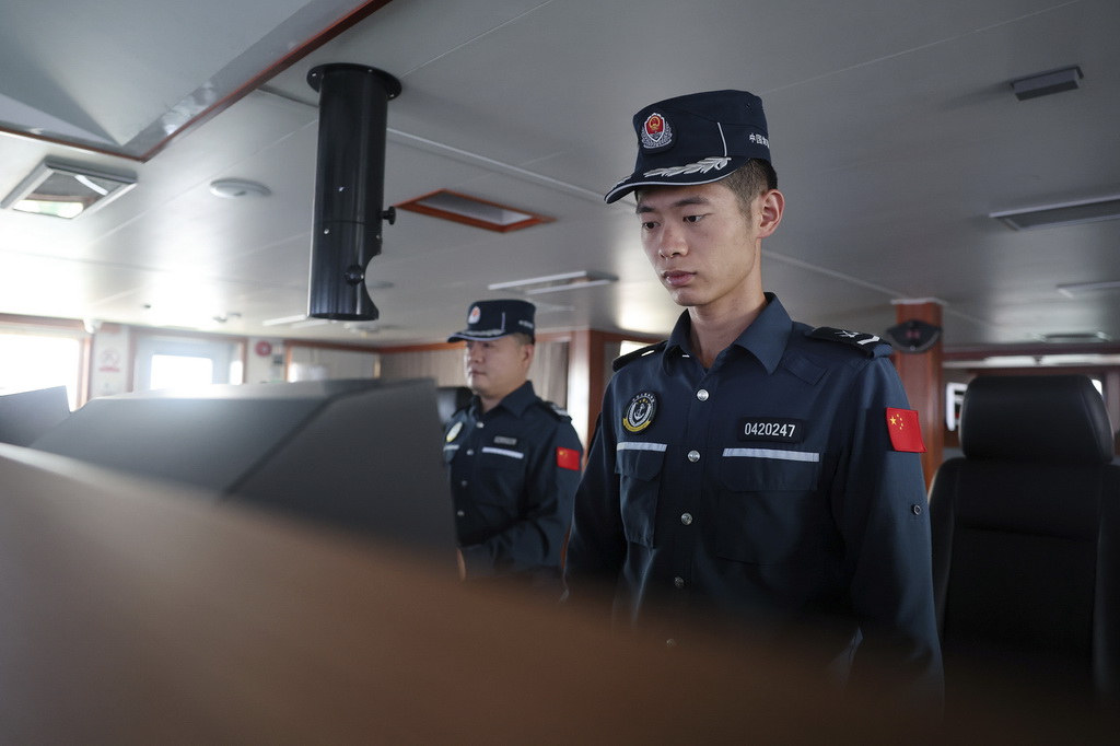 5月5日，海警川山舰执法员廖静龙（右）在巡航警戒演练中紧盯雷达屏幕。新华社记者 陈地 摄