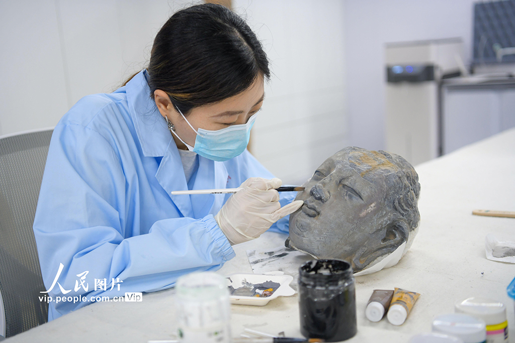2026年5月12日，河南省洛阳市，工作人员在给3D打印的佛首模型上色。