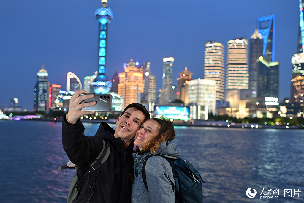 2026年4月21日，上海浦江两岸的迷人夜景吸引外国游客拍照打卡。2026年第一季度，上海口岸入境外籍旅客达146.2万人次，同比增长25.1%。其中，通过免签政策入境的旅客为91.9万人次，占入境外籍旅客总量的62.9%。持续扩大的免签“朋友圈”，正成为吸引全球游客到访上海的核心引擎。人民网记者 翁奇羽摄
