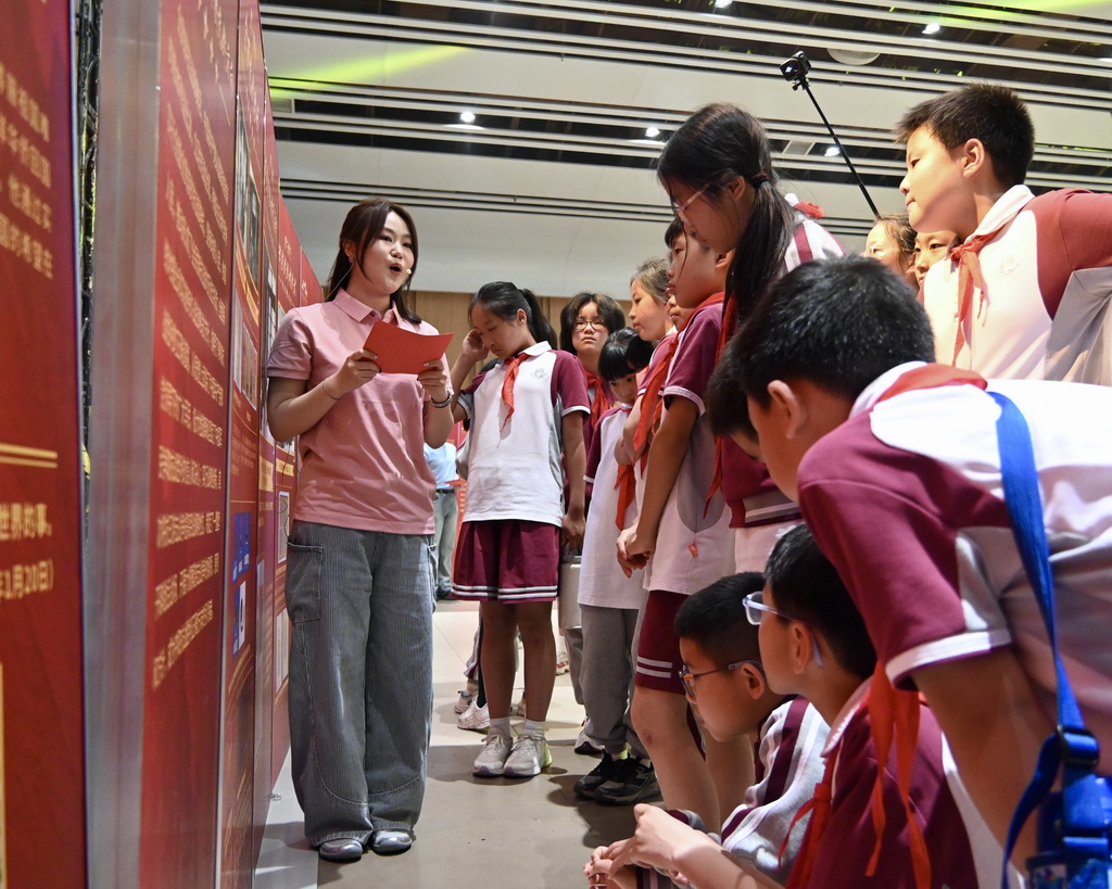 5月19日，北京城市学院学生（左）给北京大学附属小学学生讲解抗战文物展内容。