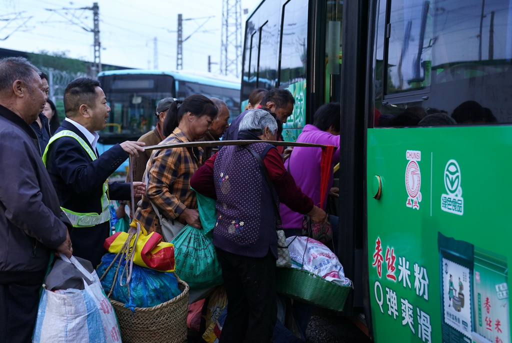 菜農在江西省南昌縣向塘鎮浹溪村的公交站點上車（5月9日攝）。