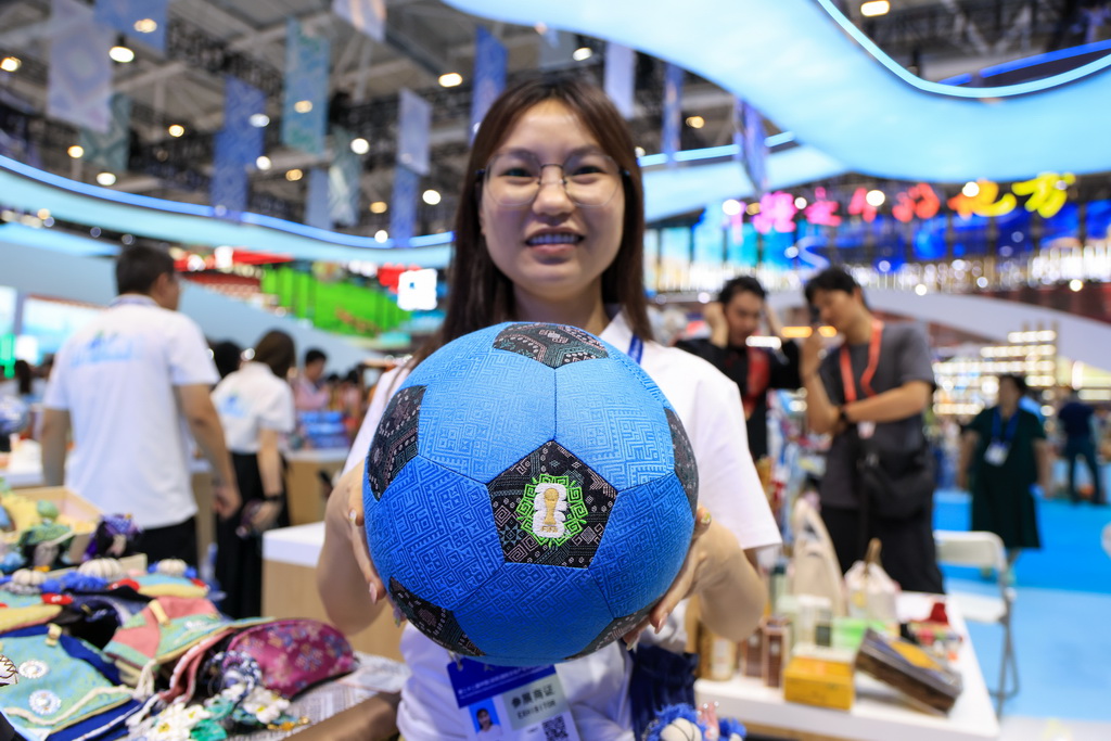 5月21日，工作人员在广西馆展示广西壮锦与2026年世界杯合作的文创产品。