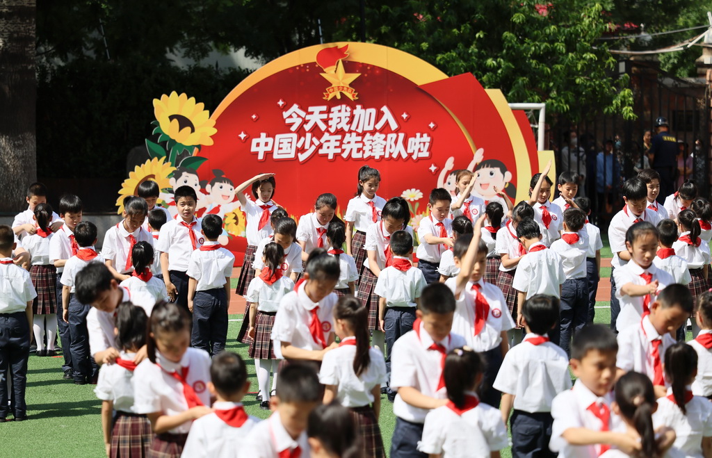 5月27日，高年级队员代表为新队员佩戴红领巾。