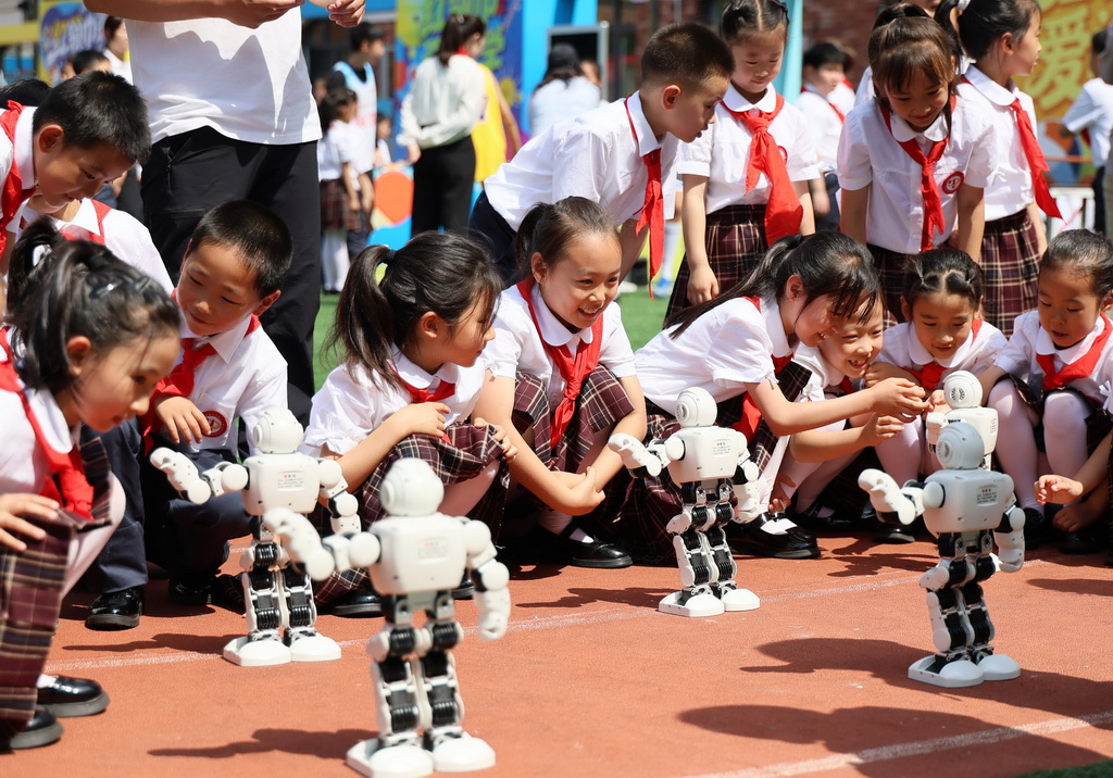 5月27日，少先队员在流动少年宫观看机器人舞蹈。