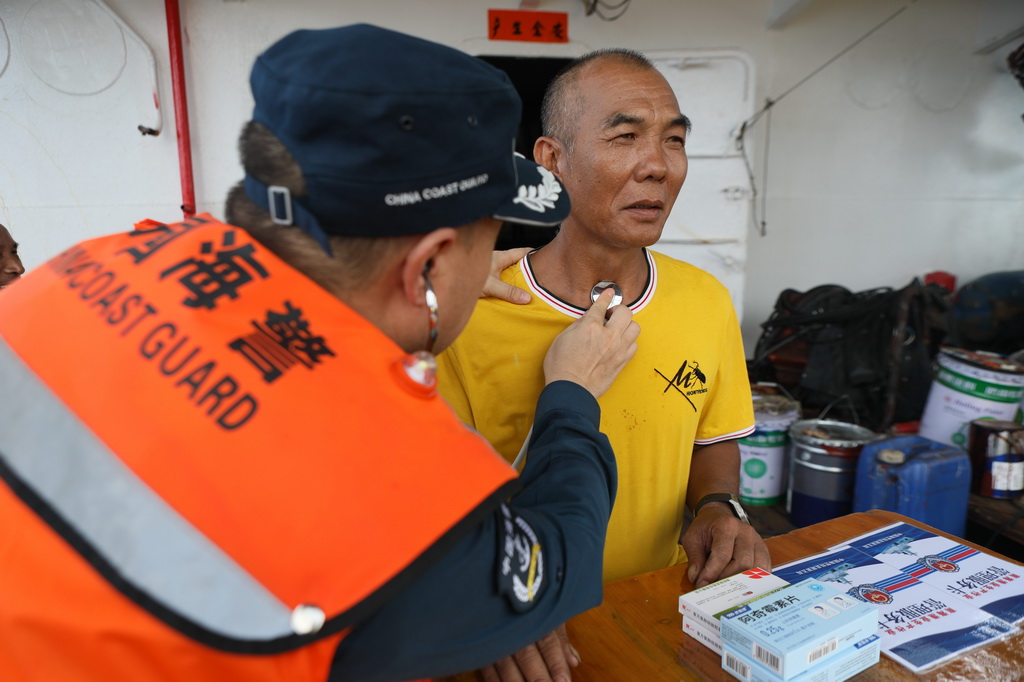 5月23日，中国海警东安舰执法员为渔民检查身体。