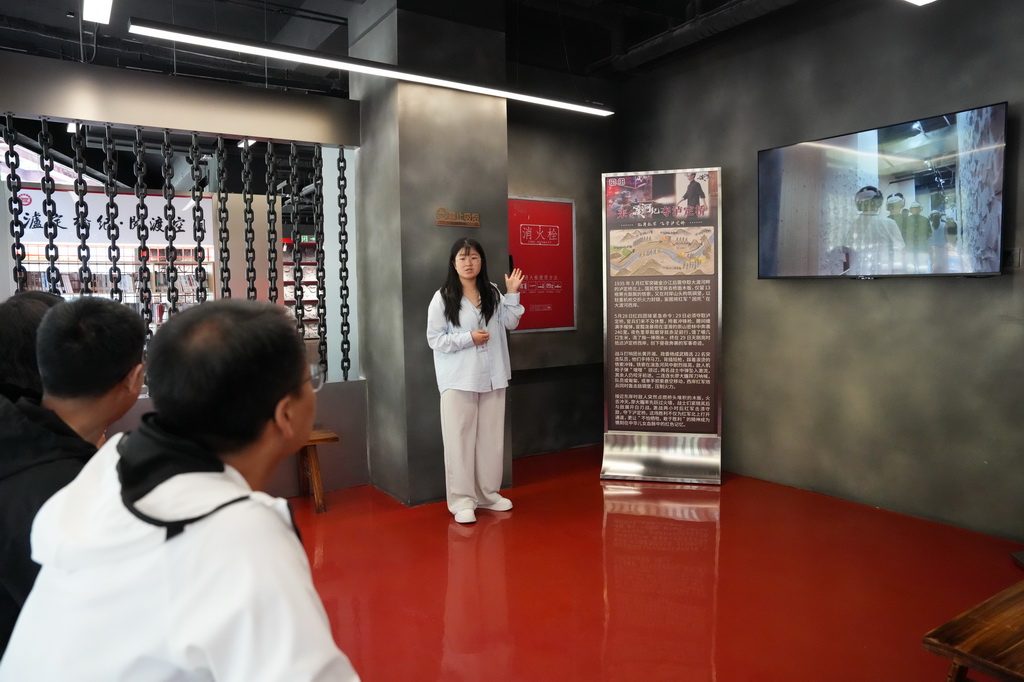 5月19日,在泸定桥旁的“飞夺泸定桥·渡河纪”全感互动空间,工作人员向游客介绍剧情。新华社记者 胥冰洁 摄