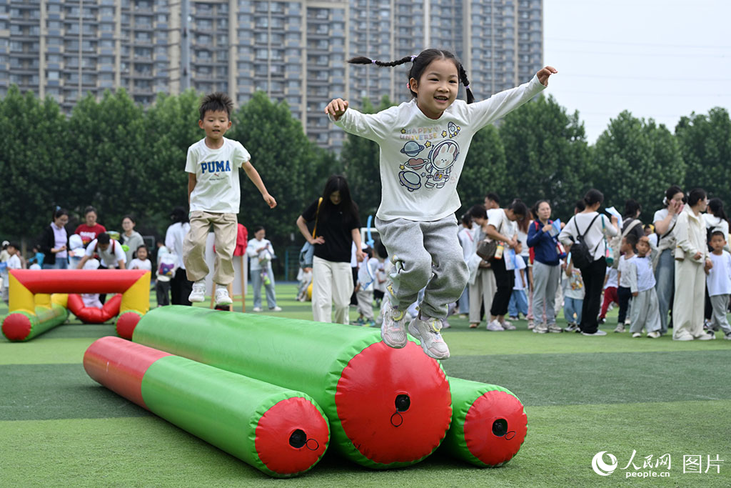 2026年5月27日，山东济南历下区百合幼儿园“六一”亲子运动会现场，孩子们跟随音乐节拍快乐跃动，一张张灿烂笑脸定格了纯真而充满活力的美好瞬间。人民网记者 刘祺摄