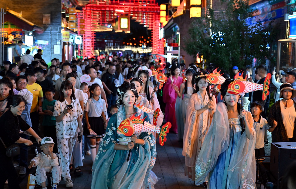6月5日,游客在京杭大运河沧州段沿线的南川老街观看巡游表演。新华社记者 郭程 摄