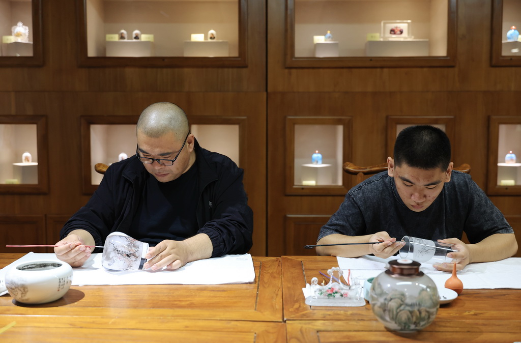 6月7日，在衡水内画艺术博物馆，艺人李广田（左）与他的儿子李嘉诚在创作内画。新华社记者 张晨霖 摄