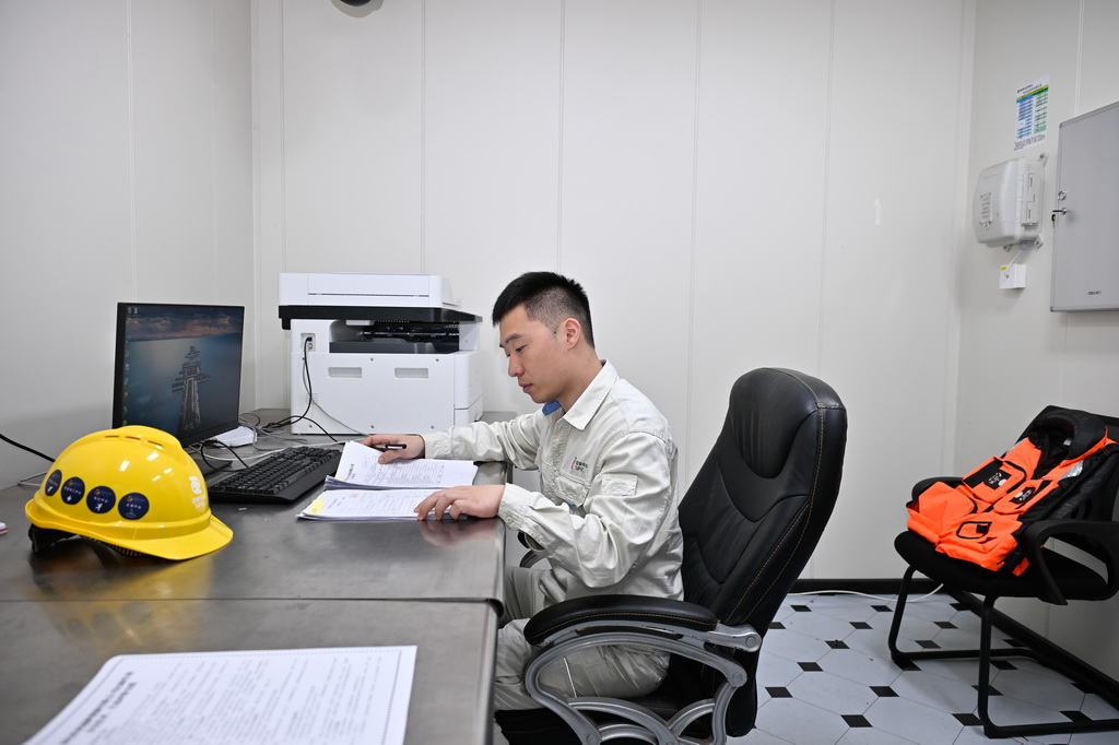 6月10日，在如东H4海上风电场220千伏升压站，运行班班长纪成在给维检人员审核工作票。