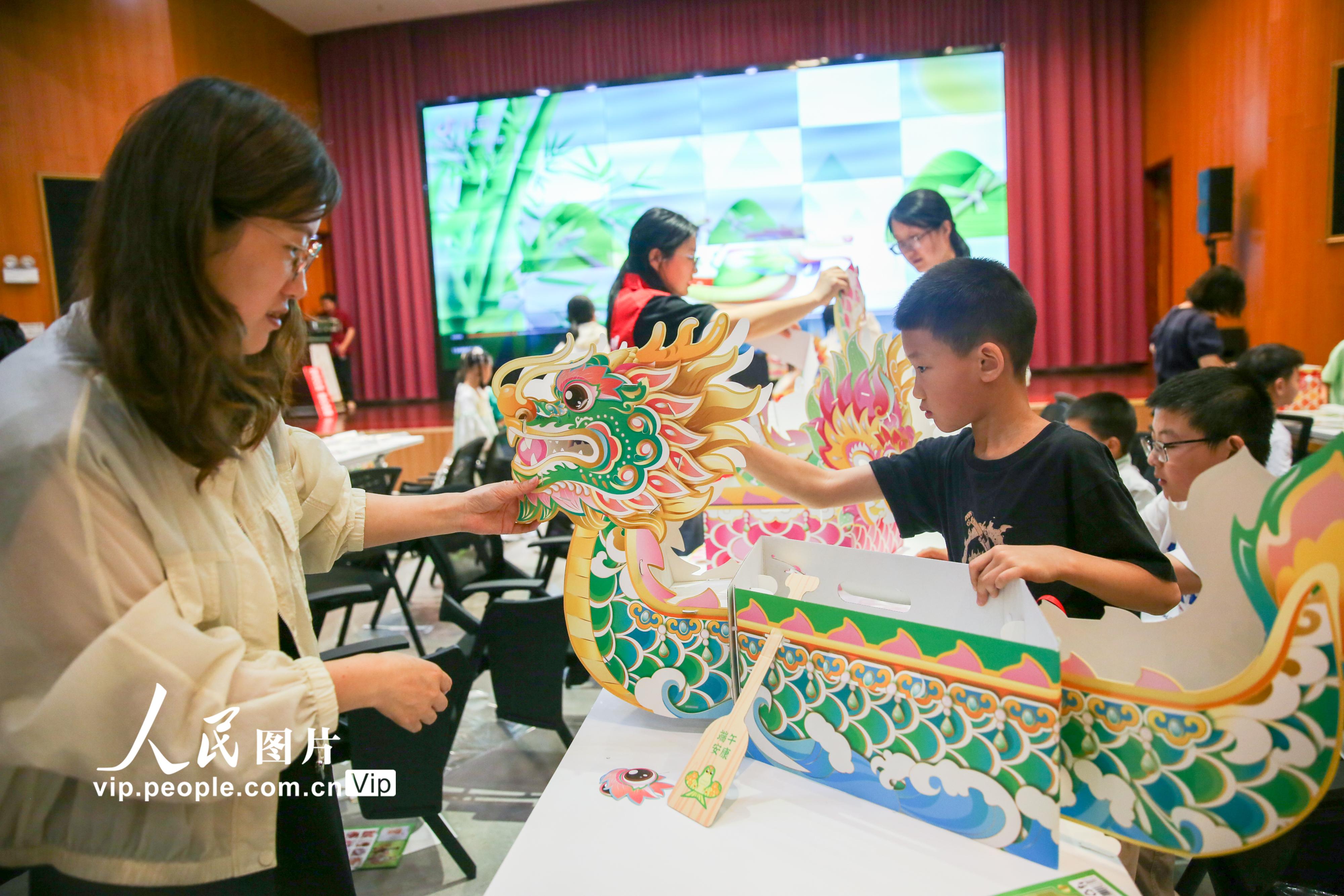 2026年6月14日，在江苏省如皋市新时代文明实践中心内，大小朋友携手制作龙舟模型。