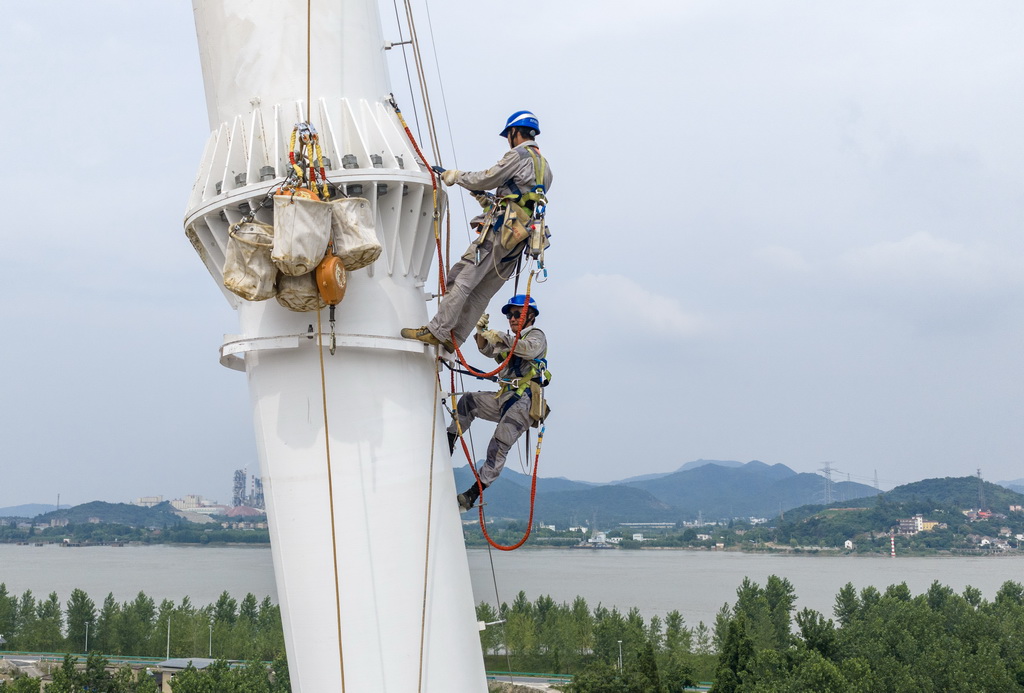 6月17日，安徽送变电工程有限公司施工人员在甘浙特高压长江大跨越北岸跨越塔组立现场作业（无人机照片）。