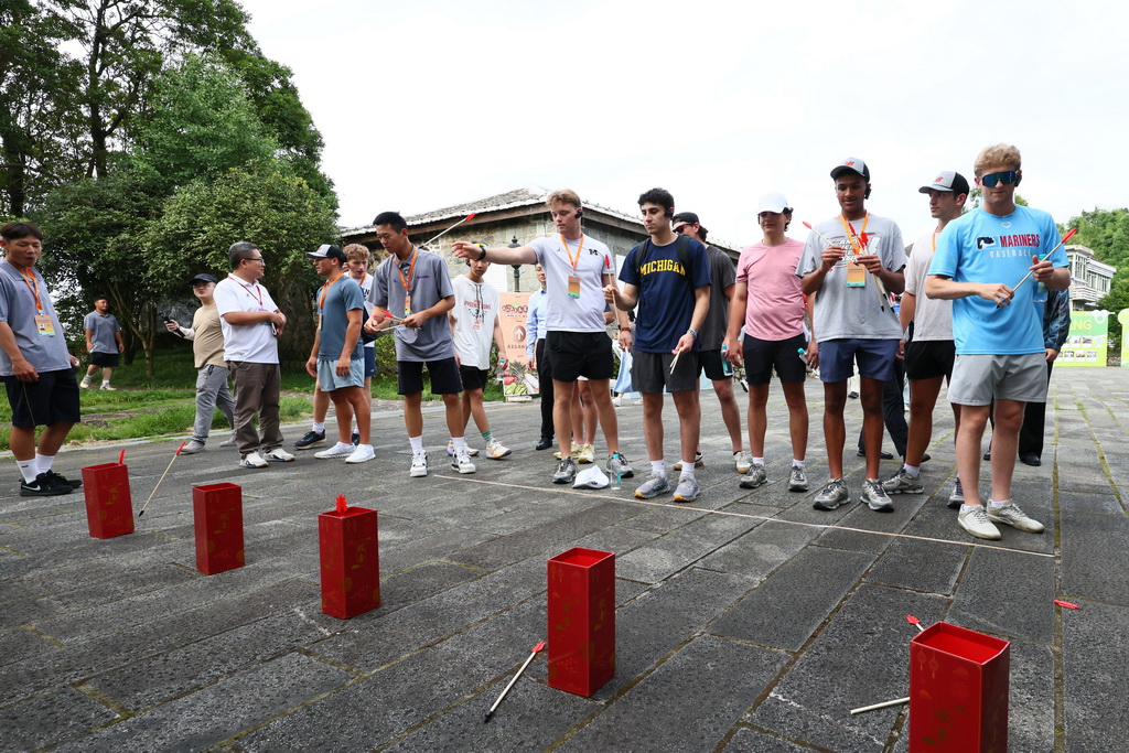 6月29日，在福州鼓岭参观的美国青年学生在万国公益社前玩“投壶”游戏。