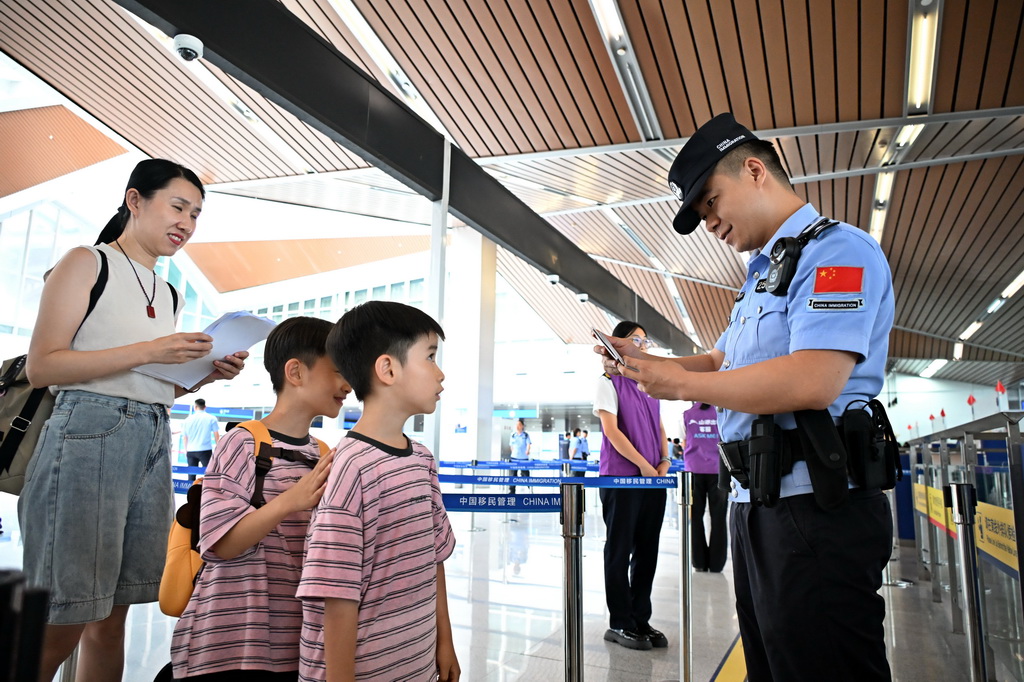 7月1日，青岛边检站民警在对出境旅客进行人证对照检查。