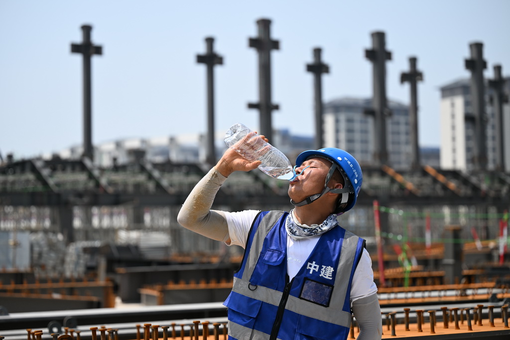 7月2日，中建二局工人在北京科技大學雄安校區建設現場喝水解暑。