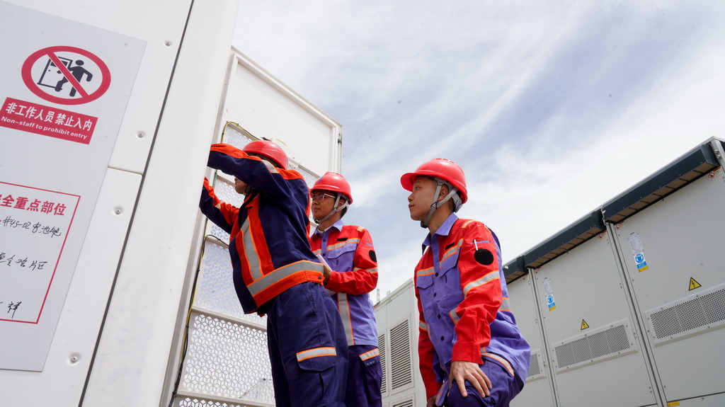 7月8日，在青海省海西蒙古族藏族自治州德令哈市的华电德令哈100万千瓦光储项目及3兆瓦光伏制氢项目基地内，工作人员对储能电站进行巡检。新华社记者 王艳 摄