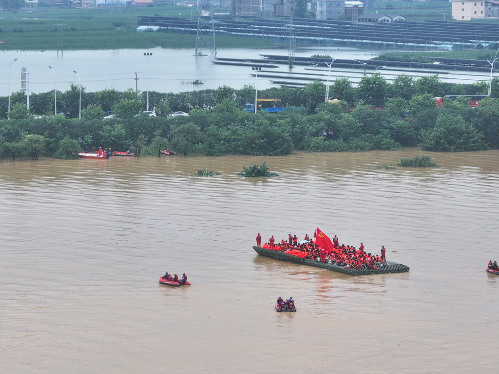 7月9日，在广西贵港市西江教育园区，救援人员使用动力舟桥转运被困人员（无人机照片）。新华社记者 曹祎铭 摄