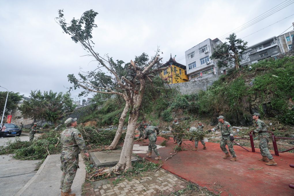 7月12日，在浙江台州玉环市坎门街道鹰东社区，玉环人武部应急连民兵清理被大风刮倒的树枝树杈。新华社记者 徐昱 摄