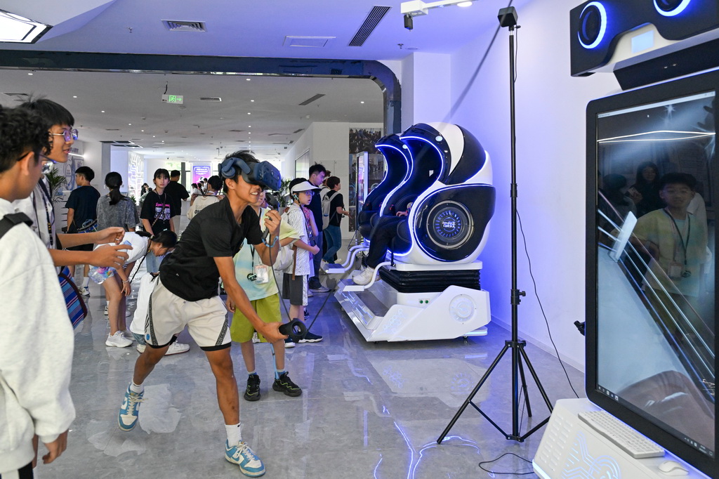 7月11日，两岸青少年在重庆机器人AI应用展示中心体验虚拟现实互动。