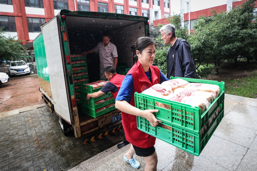 7月14日,在沈阳市辽中区第一高级中学临时安置点,工作人员接收爱心企业捐赠的食品。新华社记者 潘昱龙 摄
