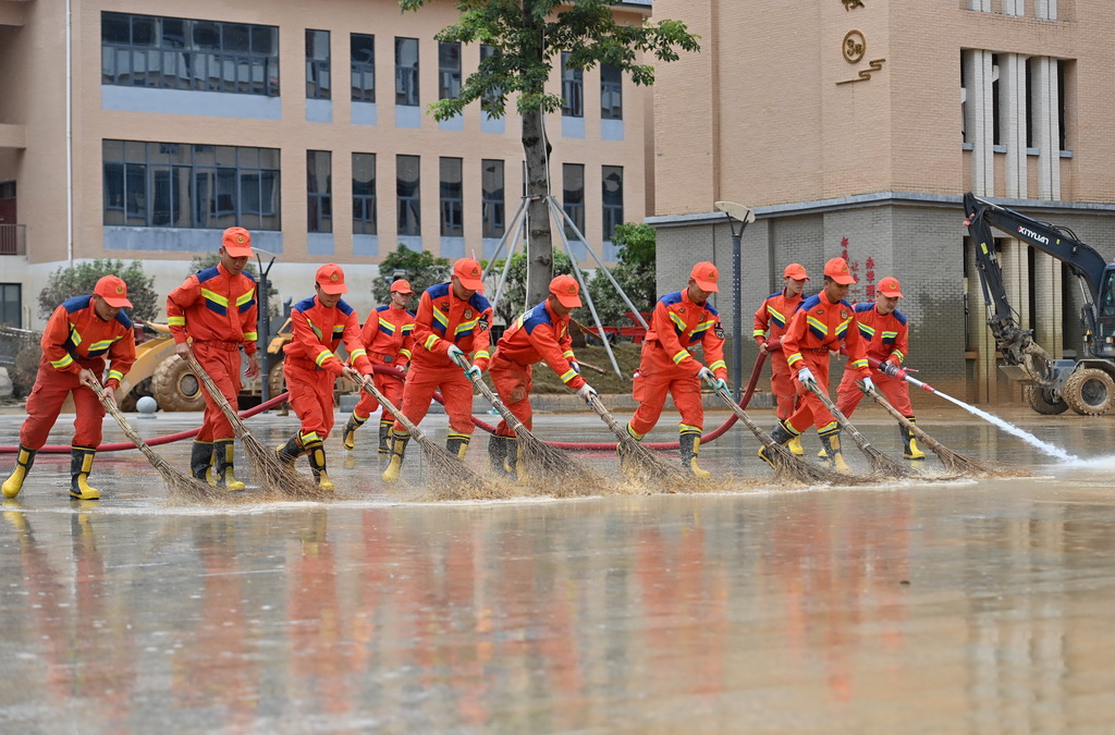7月15日，人们在广西贵港市高级中学开展清淤作业。新华社记者 陆波岸 摄