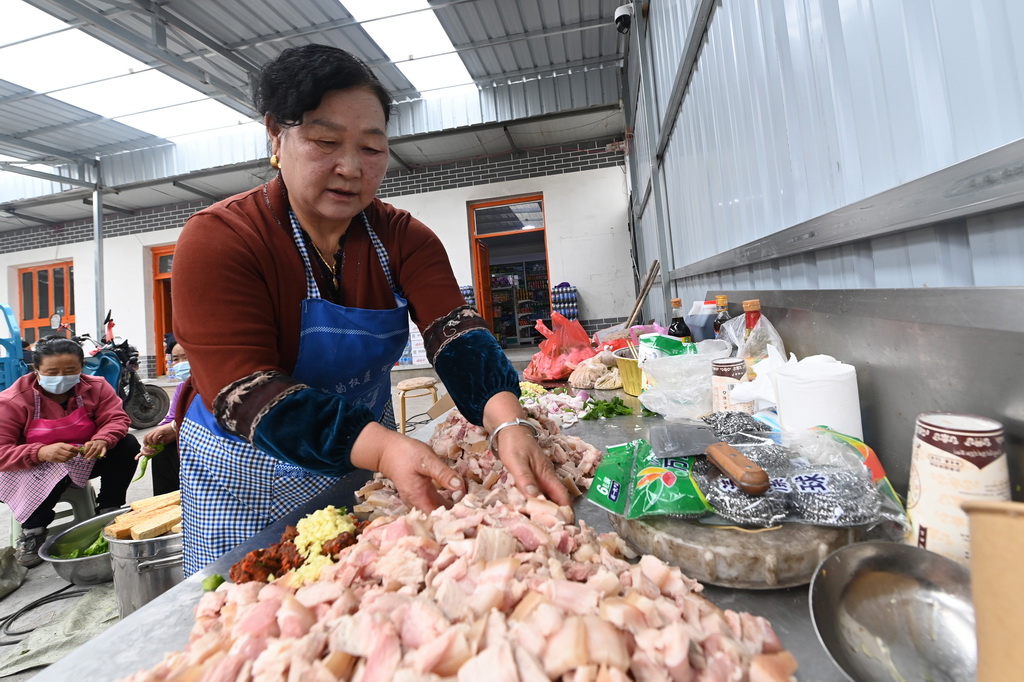 7月16日，在麻当镇“7·13山洪灾害”临时安置点，村民在准备午饭的食材。新华社记者 刘克英 摄