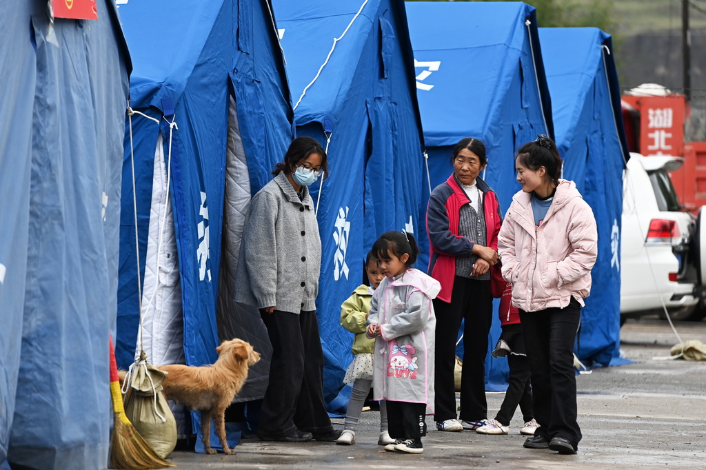 7月16日,在麻当镇“7·13山洪灾害”临时安置点,村民在帐篷外聊天。新华社记者 范培珅 摄