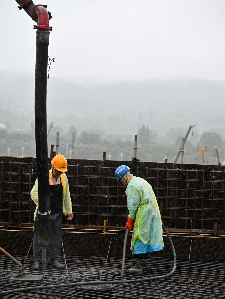 7月20日，中铁建设集团工人在南京北站建设现场进行混凝土浇筑作业。