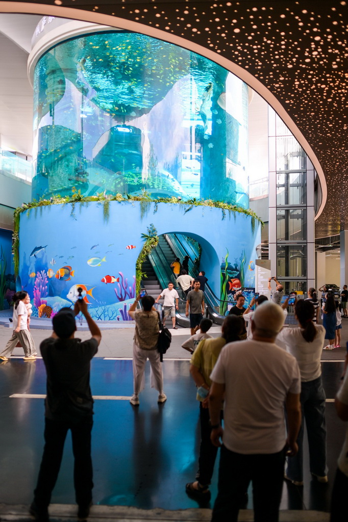 7月21日，过往旅客在杭千高速桐庐服务区参观水族景观。