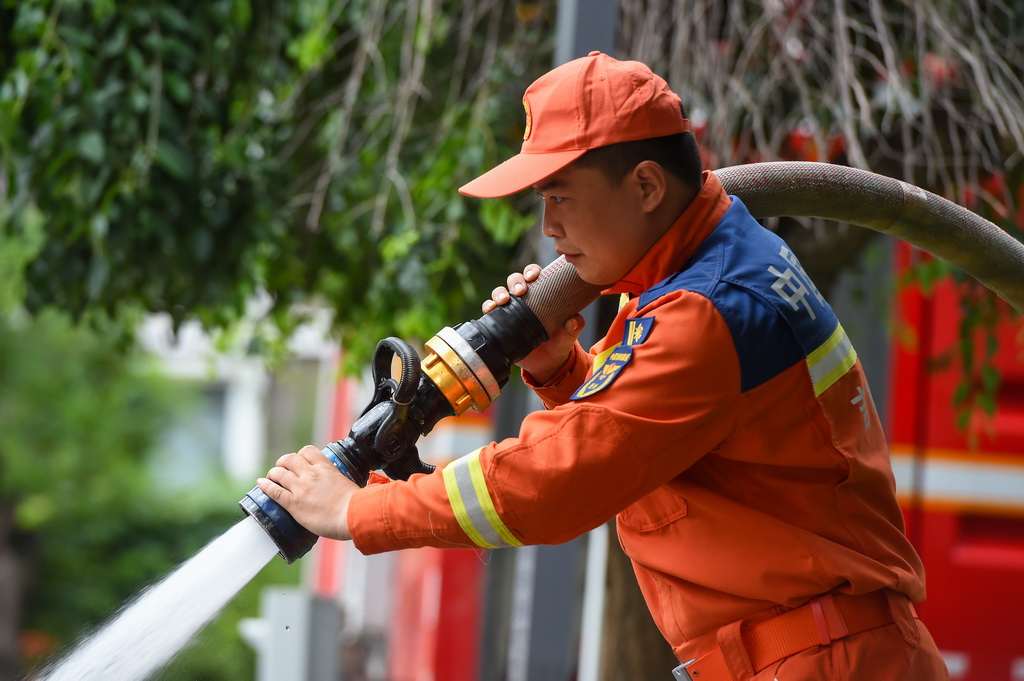 7月21日，敦化市消防救援大队指战员在康惠花园小区冲洗道路淤泥。
