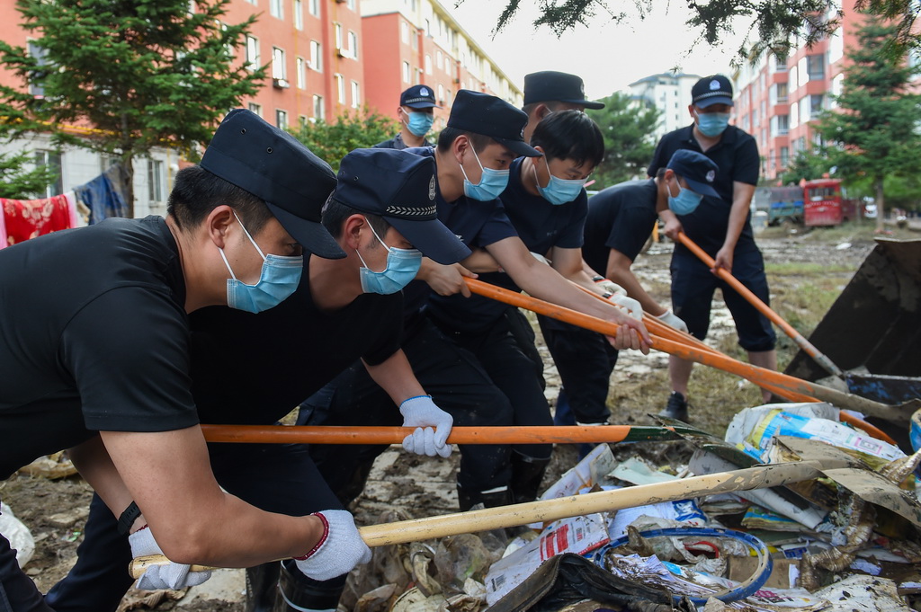 7月20日，吉林省延边朝鲜族自治州公安局公安干警在敦化市玫瑰园小区清理垃圾。