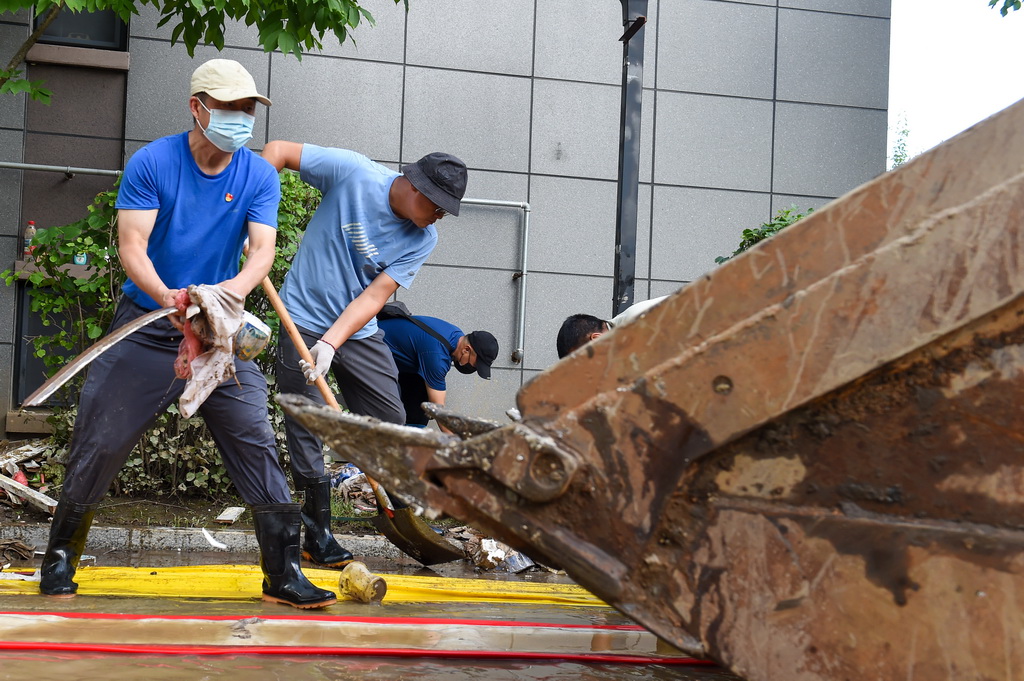 7月20日，敦化市教育局党员先锋队队员在源科壹号院小区清理垃圾。