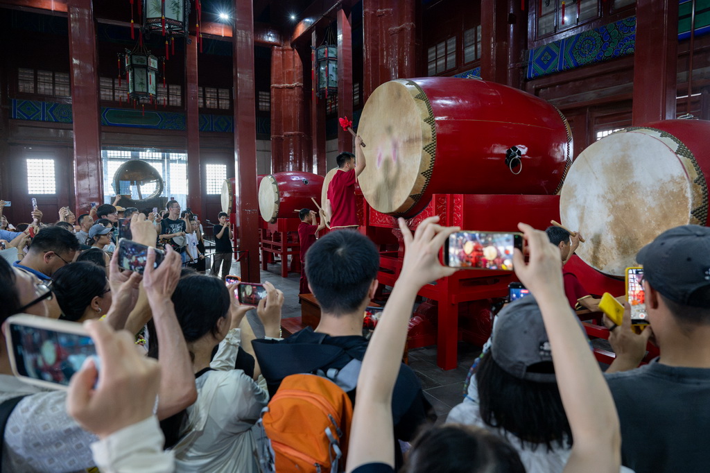 7月27日，游客在北京鼓楼观看表演。新华社记者 胡竞文 摄