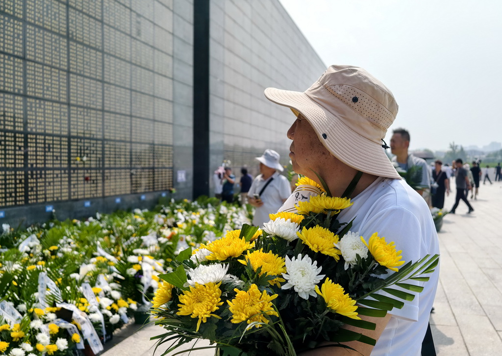 7月28日，市民在唐山地震遗址纪念公园的纪念墙前献花。新华社记者 杨世尧 摄
