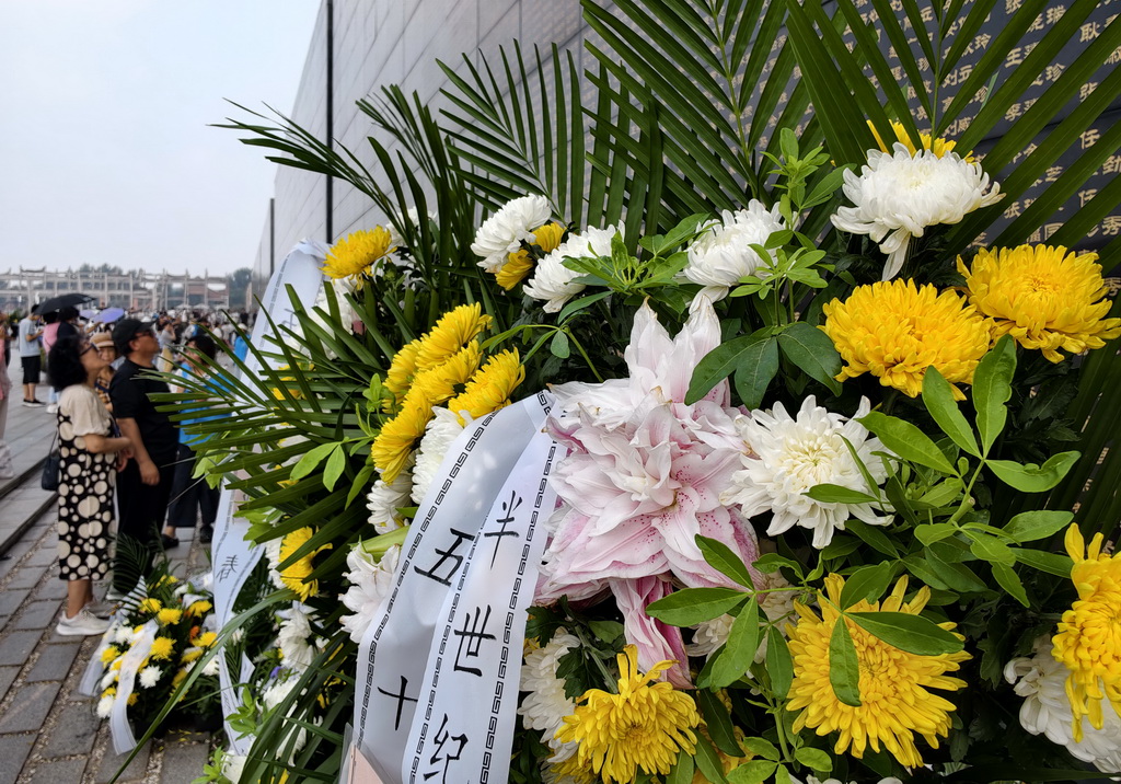 7月28日，市民在唐山地震遗址纪念公园的纪念墙前献花。新华社记者 杨世尧 摄