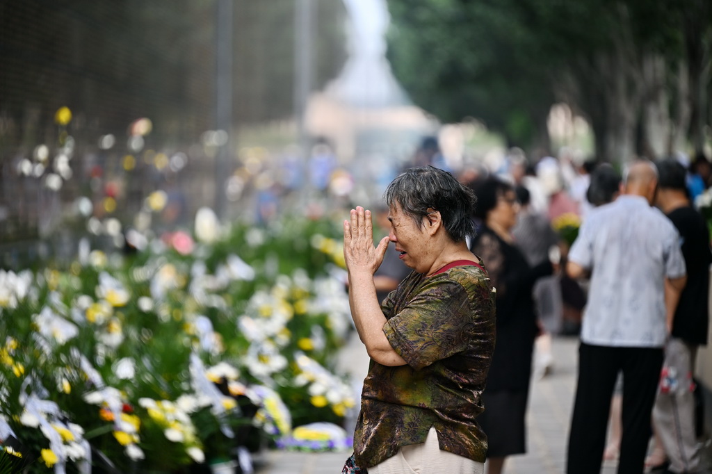 7月28日，市民在纪念墙前祭奠遇难的亲人。新华社记者 牟宇 摄