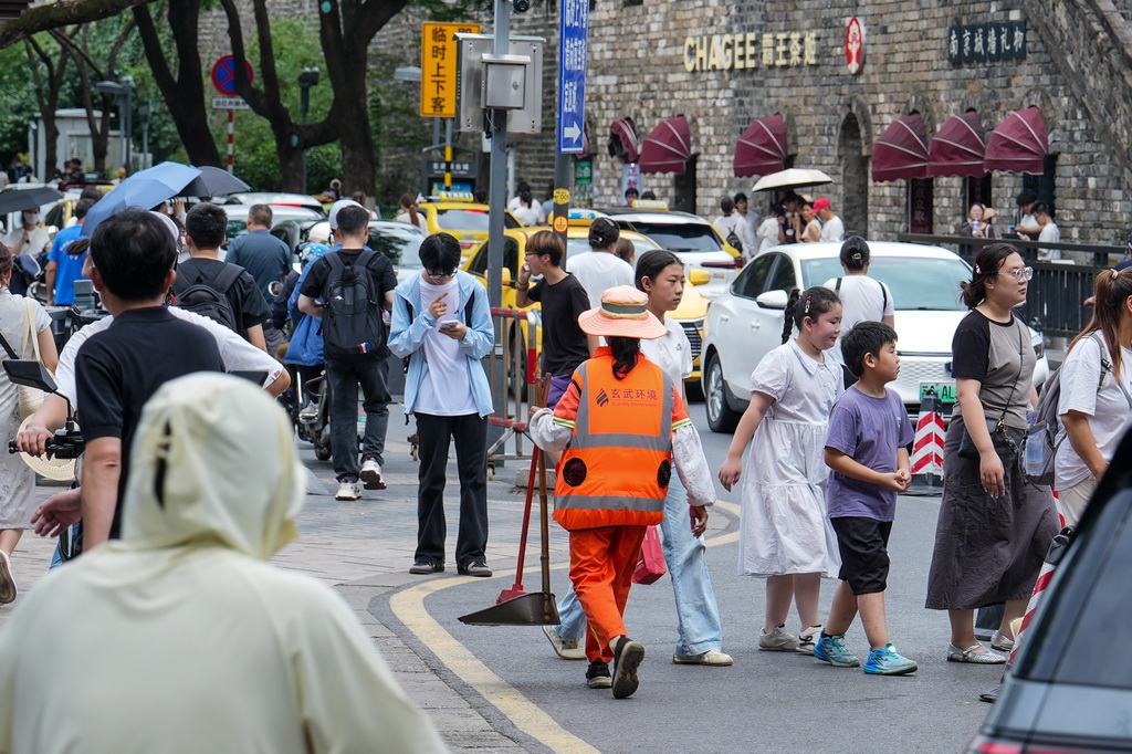 7月28日，环卫工人身穿“空调马甲”在街头工作。