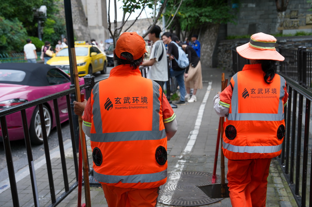 7月28日，环卫工人身穿“空调马甲”在街头工作。