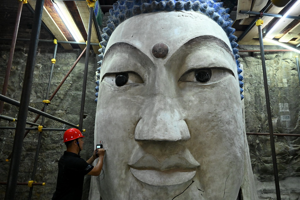 7月29日,专业技术人员在河南浚县大伾山摩崖大佛修缮现场开展工作。