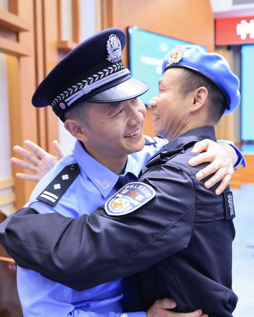7月30日，维和警队队员（右）在出征仪式后与战友拥抱告别。