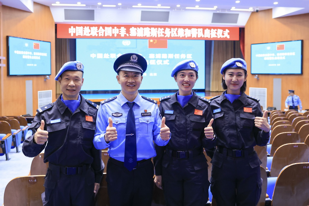 7月30日，维和警队队员在出征仪式后与战友（左二）留影。
