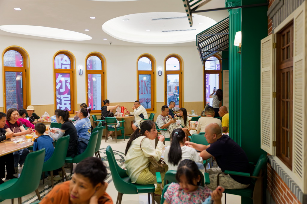 7月29日，游客在位于哈尔滨道外区的老字号商店里吃冷饮。新华社记者 张涛 摄