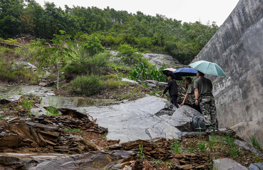 8月2日，在陇南市武都区枫相乡草坪村，乡镇干部和村内网格员冒雨核查一处地质灾害隐患点。