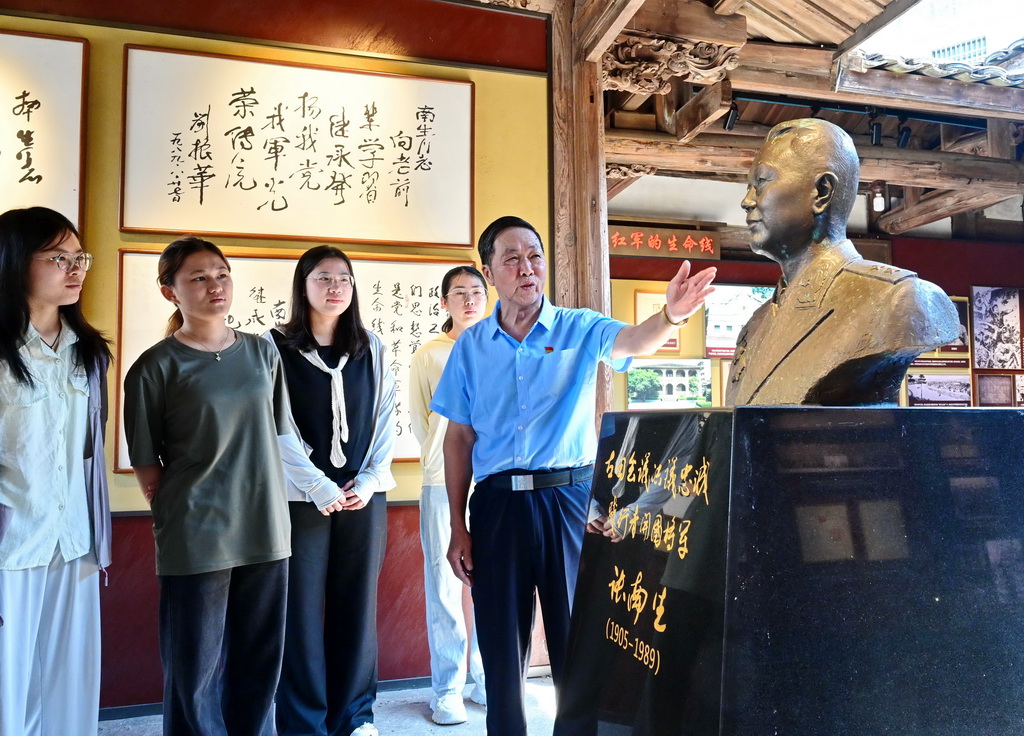 8月7日，义务讲解员张开涛（右一）在位于连城县新泉镇的张南生将军故居为参观者讲解。