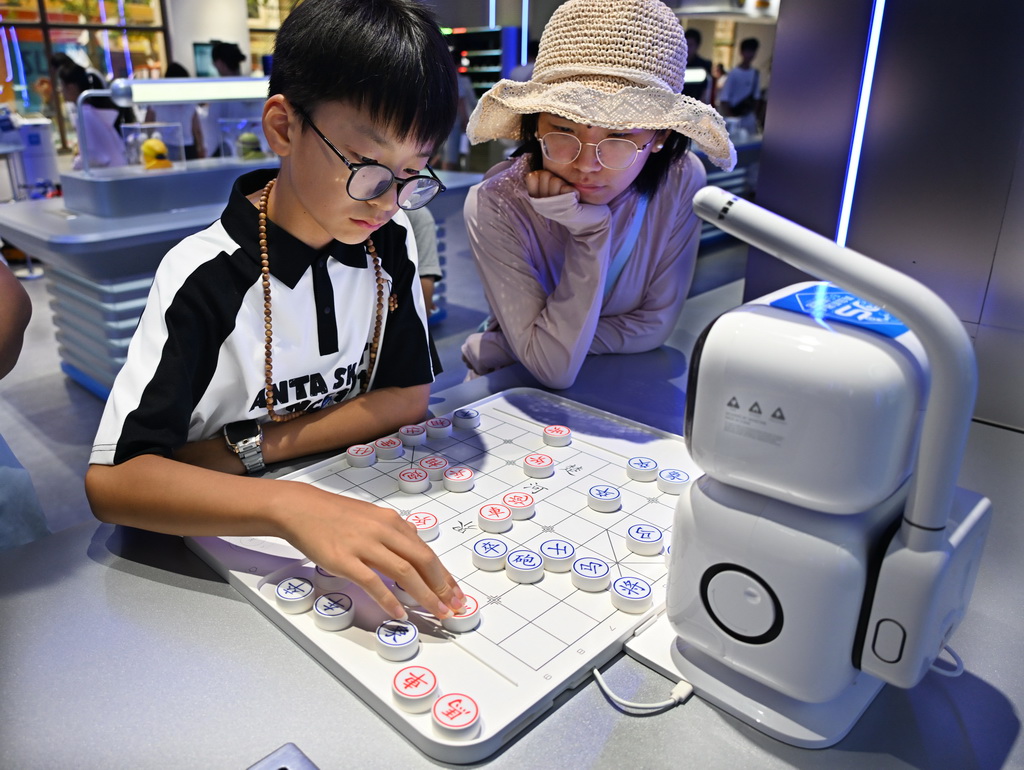 8月11日，消费者在青岛机器人6S体验店与机器人对弈。