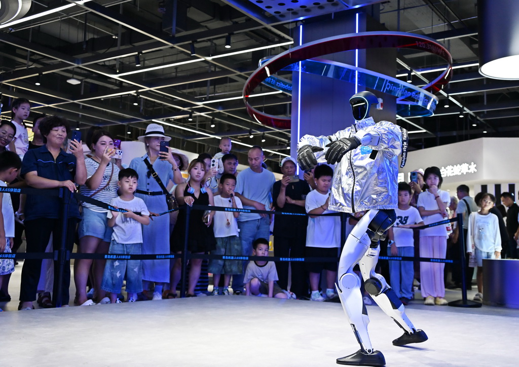 8月11日，消费者在青岛机器人6S体验店观看机器人表演。