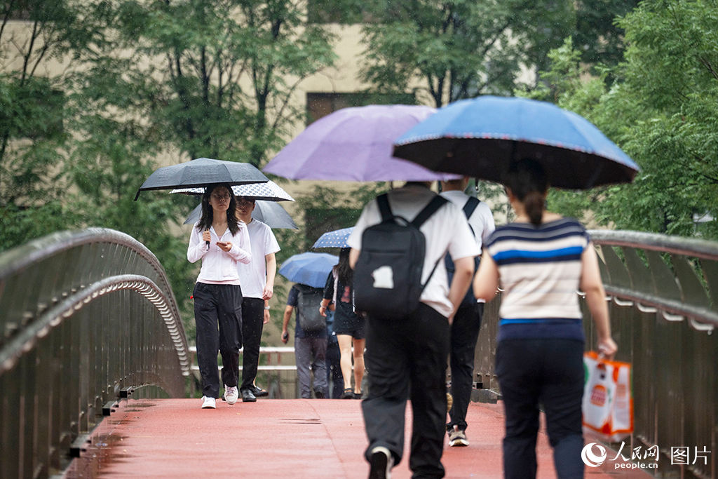 2026年8月12日，北京国贸，行人在暴雨中行进。